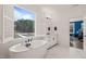 Bathroom with standalone tub, large window view, and marble floors at 1121 White Oak Creek Dr, Apex, NC 27523