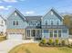 Inviting two-story home featuring brick accents, a well-maintained lawn, and a welcoming front porch at 1121 White Oak Creek Dr, Apex, NC 27523