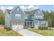 Charming two-story home with a well-manicured lawn and a three-car garage, enhanced by brick and siding accents at 1121 White Oak Creek Dr, Apex, NC 27523