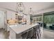 A bright kitchen features an island with seating, modern lighting, and access to an outdoor deck at 1121 White Oak Creek Dr, Apex, NC 27523