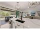 A kitchen island with a sink, quartz countertop, and modern lighting connects to an outdoor deck at 1121 White Oak Creek Dr, Apex, NC 27523