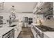 A modern kitchen is shown with white cabinets, stainless steel appliances, and a geometric chandelier at 1121 White Oak Creek Dr, Apex, NC 27523