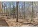 View of backyard with wooded landscape, deck, and stair access to the home at 1133 Turner Farms Rd, Garner, NC 27529