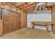 Unfinished basement with exposed ceiling and ductwork, and a workbench and double doors at 1133 Turner Farms Rd, Garner, NC 27529