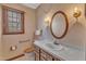 Cozy bathroom features a vanity, oval mirror, and wallpaper, exuding vintage charm at 1133 Turner Farms Rd, Garner, NC 27529