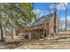 Rear elevation of brick home featuring upper deck, covered patio, and wooded lot at 1133 Turner Farms Rd, Garner, NC 27529