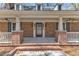 Inviting covered front porch with brick columns and black front door at 1133 Turner Farms Rd, Garner, NC 27529
