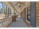 Spacious covered porch featuring brick columns, ceiling fans, and natural light at 1133 Turner Farms Rd, Garner, NC 27529
