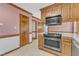Kitchen featuring stainless steel appliances, wood cabinets, and access to other rooms at 1133 Turner Farms Rd, Garner, NC 27529