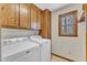 Bright laundry room with washer, dryer, and built-in wooden cabinets for storage at 1133 Turner Farms Rd, Garner, NC 27529