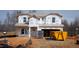 New construction home with Tyvek wrap, showing framing and preparation for exterior finishes with construction debris in front at 1135 Winding Spring Dr, Mebane, NC 27302