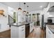 Stylish kitchen featuring a center island, stainless steel appliances, and an open layout to a patio and staircase at 1208 Garner Rd, Raleigh, NC 27610