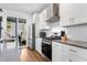 Modern kitchen featuring stainless steel appliances, white cabinets, and a sliding glass door leading to the patio at 1208 Garner Rd, Raleigh, NC 27610