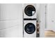 Modern laundry room features a stacked washer and dryer, maximizing space and efficiency at 1208 Garner Rd, Raleigh, NC 27610