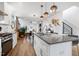 Open concept living space with modern kitchen island, dining area, and staircase leading to the upper level at 1208 Garner Rd, Raleigh, NC 27610