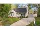 Inviting home exterior with a front porch, complemented by a lush green lawn and mature trees at 1210 Ventura Springs Ct, Wake Forest, NC 27587