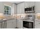 Updated kitchen featuring stainless appliances, granite countertops, and white cabinetry at 1210 Ventura Springs Ct, Wake Forest, NC 27587