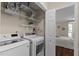 Laundry room features white machines, shelves, and access to a bedroom at 1210 Ventura Springs Ct, Wake Forest, NC 27587