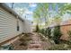 Landscaped yard with brick paver pathway, mature trees, and manicured bushes at 1210 Ventura Springs Ct, Wake Forest, NC 27587