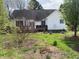 The backyard view showcasing the home, wooden deck, and lush green lawn with various plants and greenery at 126 W Quail Ridge Rd, Oxford, NC 27565