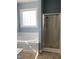 Bathroom featuring a soaking tub, a shower, and a window with privacy glass blocks at 126 W Quail Ridge Rd, Oxford, NC 27565