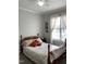 Cozy bedroom with a comfortable bed, decorative pillows, and a bright window with sheer curtains at 126 W Quail Ridge Rd, Oxford, NC 27565
