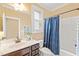 Bathroom features a window for natural light, a modern vanity, and a blue patterned shower curtain at 1524 Catch Fly Ln, Durham, NC 27713