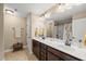 Bathroom with double sinks, dark wood cabinets, and a framed mirror and vanity lights at 1524 Catch Fly Ln, Durham, NC 27713