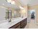 Well-lit primary bath with dual sinks, walk-in shower, and a separate door to the walk-in closet at 1524 Catch Fly Ln, Durham, NC 27713