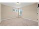 Bright bedroom with neutral carpet, paint, and natural light from two windows at 1524 Catch Fly Ln, Durham, NC 27713
