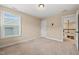 Carpeted bedroom with a window and view to the outside, and access to another room at 1524 Catch Fly Ln, Durham, NC 27713