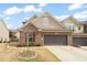 Charming brick home featuring a two-car garage, manicured lawn, and freshly planted tulip garden at 1524 Catch Fly Ln, Durham, NC 27713