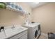 Functional laundry room with white washer, dryer, utility sink, and storage shelving at 1524 Catch Fly Ln, Durham, NC 27713