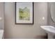 Charming powder room featuring stylish artwork and a pedestal sink at 160 Bruce Dr, Dunn, NC 28334