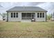 View of the back of house with screened-in porch and spacious lawn at 185 W Amber Oak Dr, Selma, NC 27576