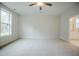 Spacious bedroom with neutral carpet, ceiling fan, and a large window letting in natural light at 185 W Amber Oak Dr, Selma, NC 27576
