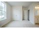 Bright bedroom featuring neutral carpet and double door closet, complemented by natural light from a window at 185 W Amber Oak Dr, Selma, NC 27576