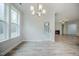 Bright dining room with large windows and modern chandelier. Adjacent door leads to outdoor space at 185 W Amber Oak Dr, Selma, NC 27576