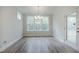 Bright dining room features wood-look flooring, modern chandelier, and plentiful natural light from large windows at 185 W Amber Oak Dr, Selma, NC 27576
