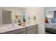 Bathroom featuring double sinks with gray cabinets and quartz counters and a view into the bedroom at 201 Olive Branch St, Sanford, NC 27332
