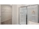Modern bathroom with a glass-enclosed shower and an open doorway to a closet with wire shelving at 201 Olive Branch St, Sanford, NC 27332