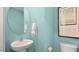 Stylish half bathroom features a modern sink, round mirror, and aqua-colored walls at 201 Olive Branch St, Sanford, NC 27332