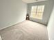 A bright bedroom with neutral paint and carpet features a large window for natural light at 204 Allen St # A/B, Creedmoor, NC 27522