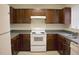 Well-lit kitchen featuring dark cabinets, a white stove, and light countertops at 204 Allen St # A/B, Creedmoor, NC 27522