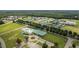 An aerial view showcasing the community center, pool, and well-maintained school buildings surrounded by lush greenery at 208 Tarkenton Ct, Clayton, NC 27527