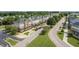 An aerial view of townhomes with manicured lawns, sidewalks, and mature trees along the street at 208 Tarkenton Ct, Clayton, NC 27527