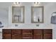 Bathroom featuring double sinks, dark wood cabinets, and large framed mirrors at 208 Tarkenton Ct, Clayton, NC 27527