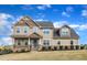 Beautiful two-story home featuring a well-manicured lawn, stone accents, and a welcoming front porch at 208 Tarkenton Ct, Clayton, NC 27527