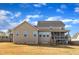A tan two story house with a covered porch and a fenced yard with an expansive lawn at 208 Tarkenton Ct, Clayton, NC 27527