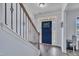Bright foyer with hardwood floors, staircase with iron spindles, and a clear view of the beautiful front door at 208 Tarkenton Ct, Clayton, NC 27527